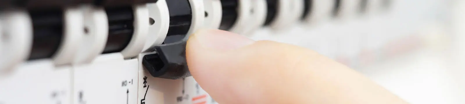 Finger, der einen Schalter an einem elektrischen Gerät betätigt, um eine Einstellung vorzunehmen.