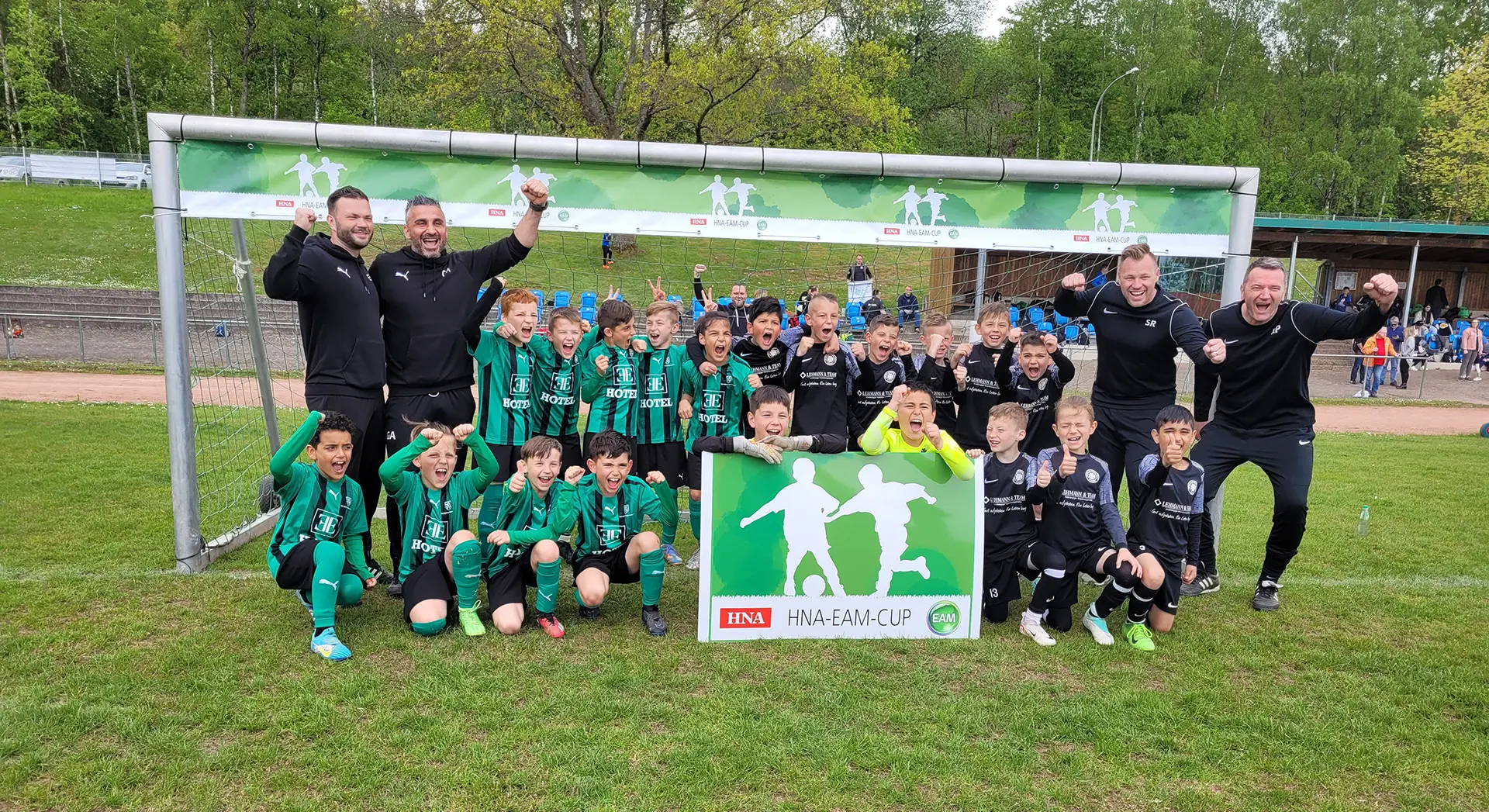 Eine Jugendfußballmannschaft feiert ihren Sieg mit den Trainern beim HNA-EAM-CUP.