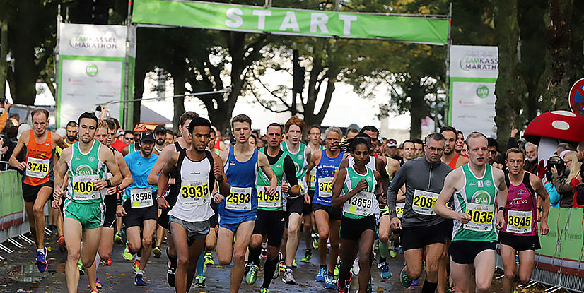 Start des Kasseler Marathons mit laufenden Teilnehmern in Sportbekleidung und Zuschauern im Hintergrund.