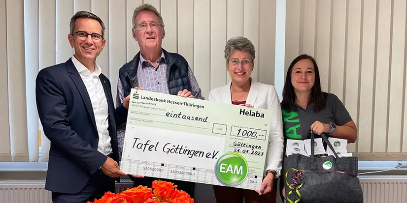 Vier Personen überreichen einen Scheck in Höhe von 1000 Euro an die Tafel Göttingen e.V. in einem hellen Raum.