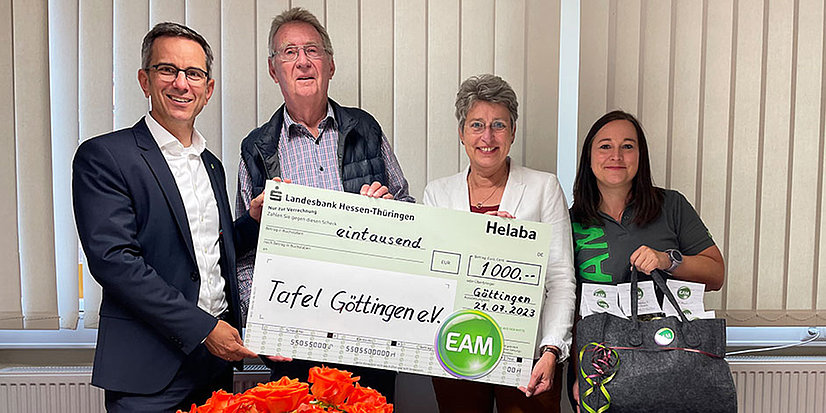 Vier Personen überreichen einen Scheck in Höhe von 1000 Euro an die Tafel Göttingen e.V. in einem hellen Raum.