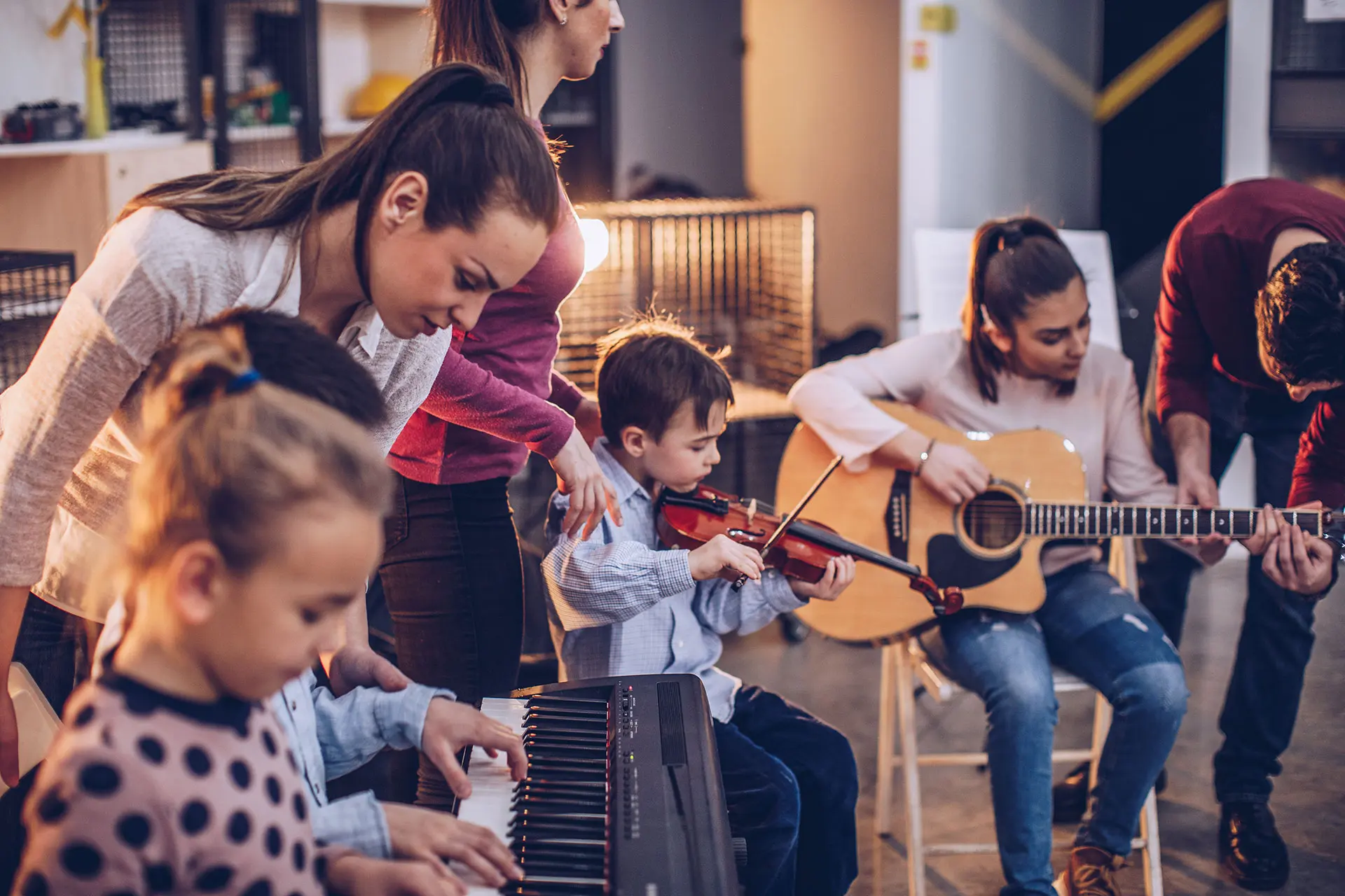 ChatGPT: Kinder spielen gemeinsam mit Erwachsenen Klavier, Geige und Gitarre in einem Musikraum bei warmem Licht.