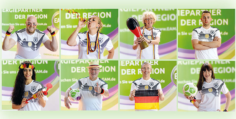 Acht Personen in deutschen Trikots feiern, tragen Fanartikel und zeigen Unterstützung für die Nationalmannschaft vor grünem Hintergrund.
