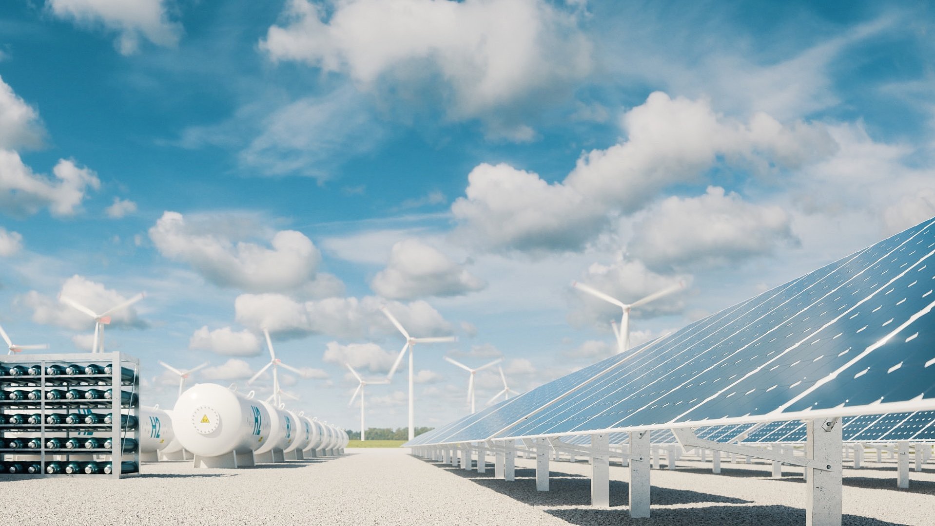 Solar- und Windenergieanlage mit Wasserstoffspeicher in einer ländlichen Umgebung, unter einem blauen Himmel mit Wolken.