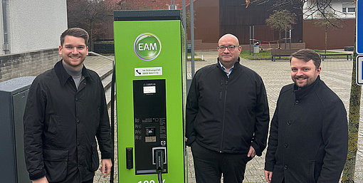Freuen sich über die neue Ladesäule in Friedewald (v. l. - stehen um die grüne EAM-Ladesäule verteilt und schauen in die Kamera): Bürgermeister Julian Kempka, Michael Bräutigam (EAM Natur Energie / E-Mobilität) und André Jüttner (Vertreter Leiter Netzregion Borken).