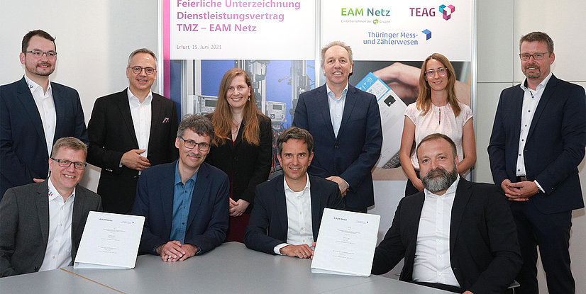 Gruppenfoto von zehn Personen bei der Unterzeichnung eines Dienstleistungsvertrags zwischen TMZ und EAM Netz.