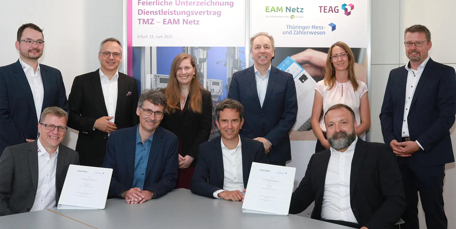 Gruppenfoto von zehn Personen bei der Unterzeichnung eines Dienstleistungsvertrags zwischen TMZ und EAM Netz.