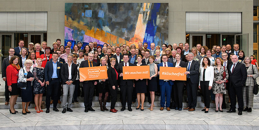 Gruppenbild von Teilnehmern einer Initiative zur Berufs- und Studienwahl, mit bunten Plakaten im Vordergrund.