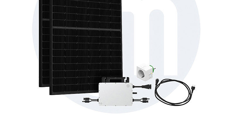Alt-Tag: Zwei schwarze Solarpanels mit Zubehörteilen wie Wechselrichter und Kabeln auf hellem Hintergrund.