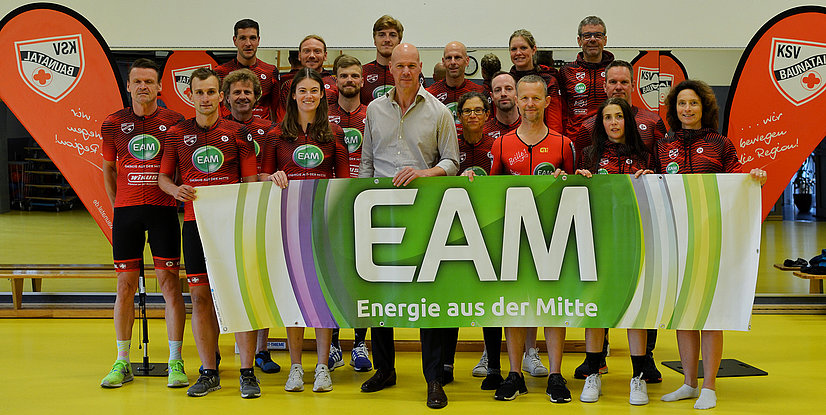Gruppensfoto des KSV Baunatal-Teams mit Banner EAM - Energie aus der Mitte vor mehreren Sponsorenflaggen.
