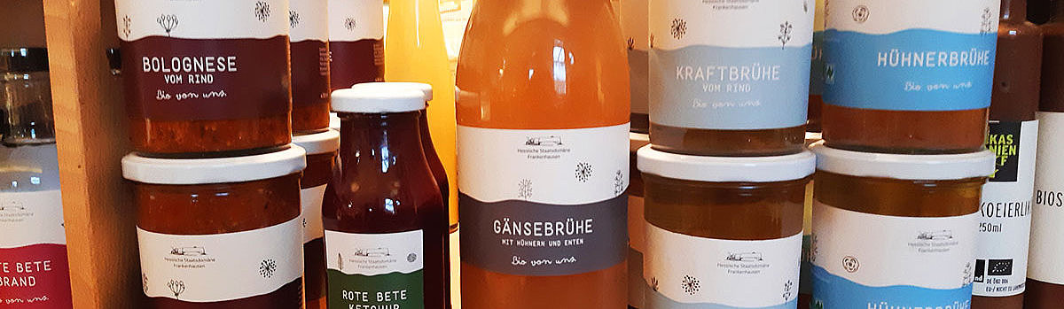Regale mit verschiedenen Gläsern und Flaschen, die hausgemachte Saucen und Brühen anbieten.