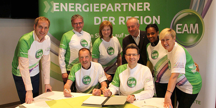 Gruppentreffen zur Unterzeichnung einer Partnerschaftserklärung mit Teilnehmern in EAM-T-Shirts.
