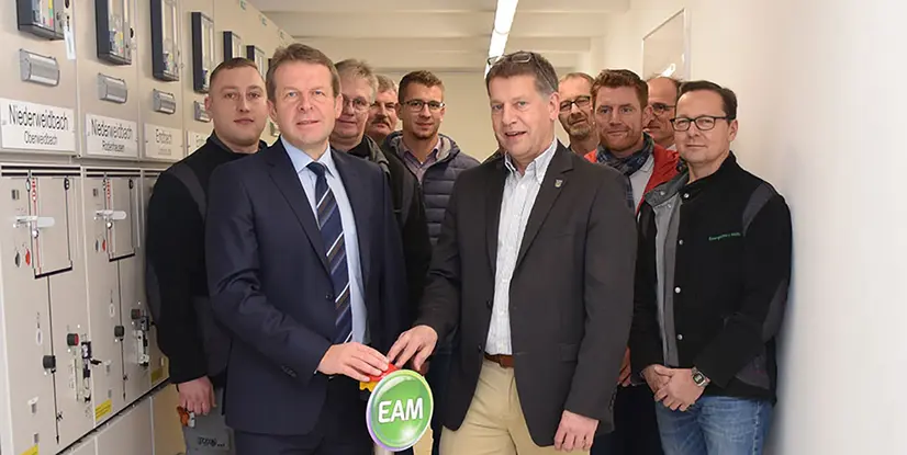 Gruppierung von Personen, die an einem Projekt arbeiten, mit einem Symbol für EAM im Vordergrund.