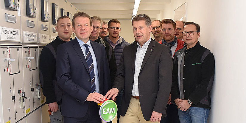 Gruppierung von Personen, die an einem Projekt arbeiten, mit einem Symbol für EAM im Vordergrund.
