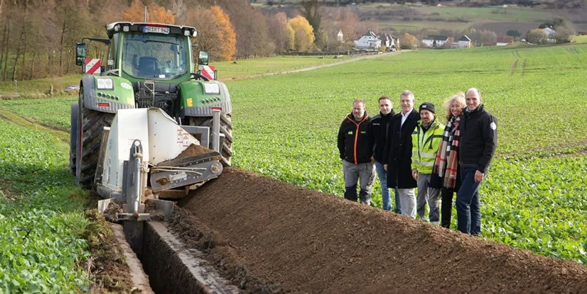orort-Termin mit Kabelfräse (v. l.): Fräsfahrer Lars Michanikl, der Leiter des Regioteams Biedenkopf Jens Urban, Gladenbachs Bürgermeister Peter Kremer, Ingo Klös von der EN Tiefbau Süd, Bad Endbachs Bürgermeisterin Erika Weber und Leiter der Netzregion Dillenburg/Biedenkopf Marcus Hief.