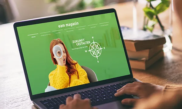 Screenshot eines Laptops mit einer Person, die einen kreativen Blick auf eine Website mit dem Titel "Zukunft Gestalten"" wirft."