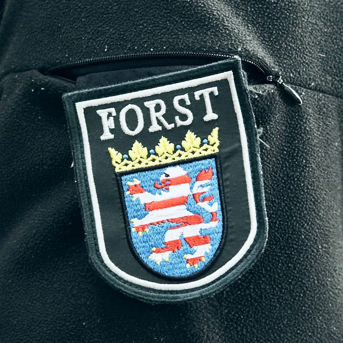 Emblem des Forsts mit Wappen und dem Schriftzug "FORST"" auf einem schwarzen Hintergrund."