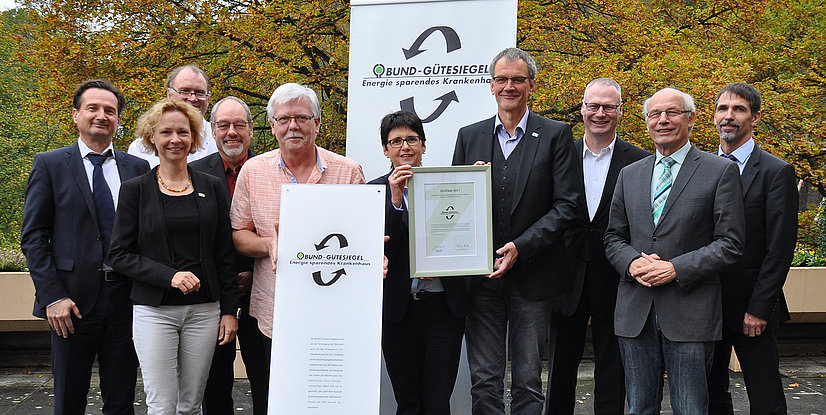 Gruppe von Personen, die ein Zertifikat für das Bund-Gütesiegel für energieeffiziente Krankenhäuser präsentieren.