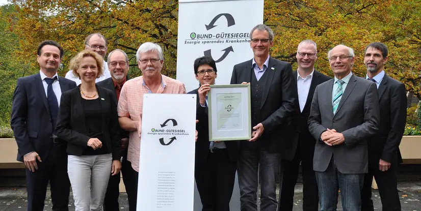 Gruppe von Personen, die ein Zertifikat für das Bund-Gütesiegel für energieeffiziente Krankenhäuser präsentieren.
