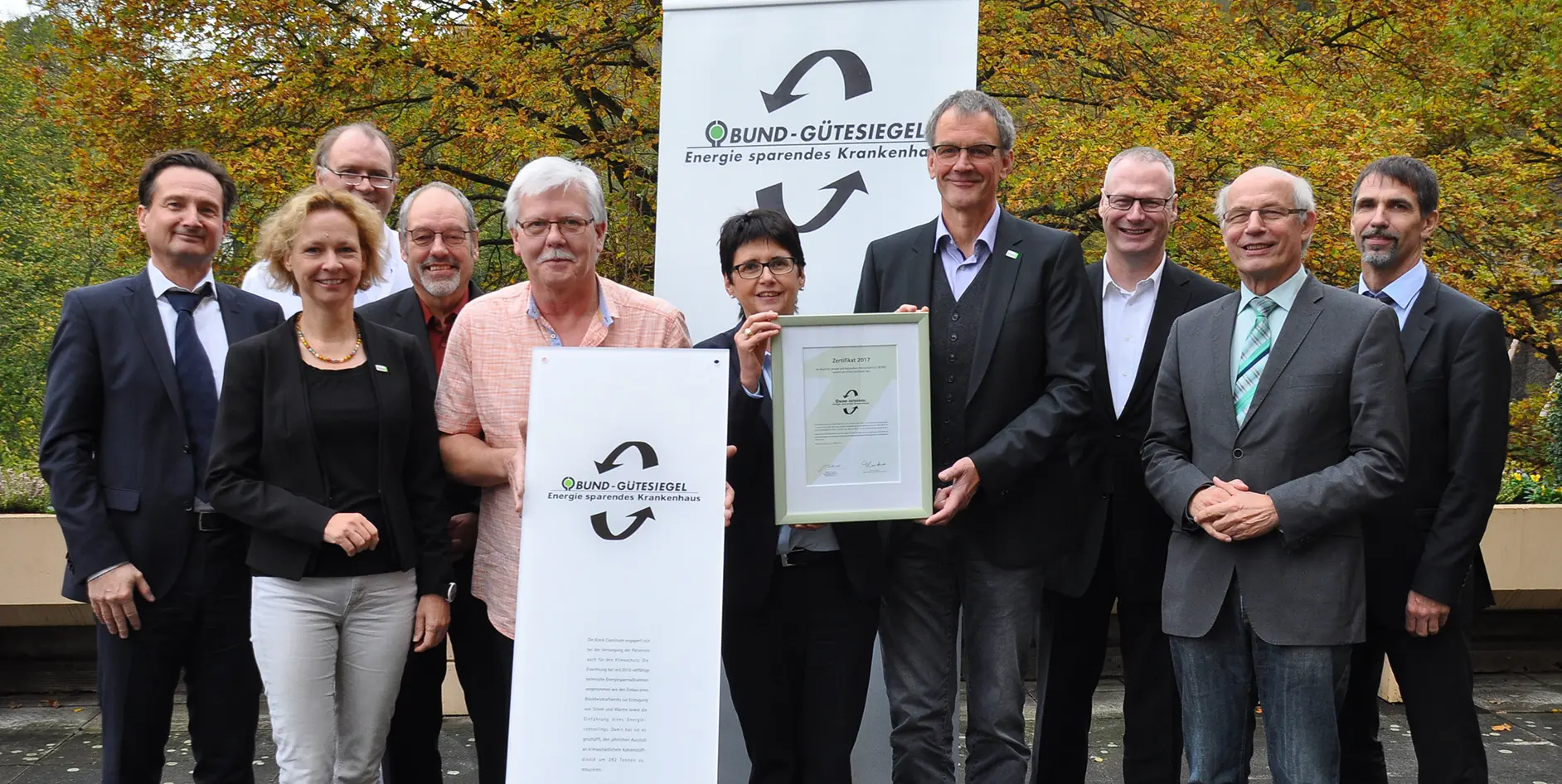 Gruppe von Personen, die ein Zertifikat für das Bund-Gütesiegel für energieeffiziente Krankenhäuser präsentieren.