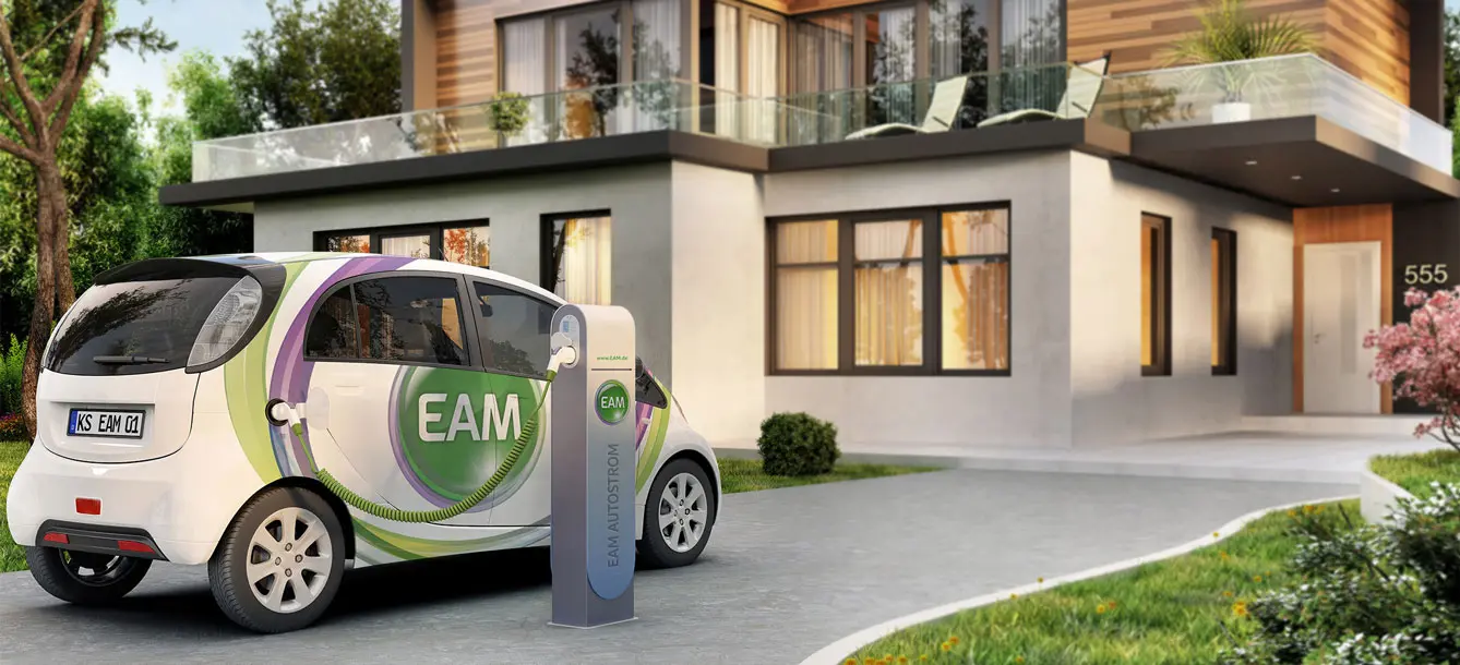 Ein Elektroauto steht an einer Ladestation vor einem modernen Haus mit Garten.