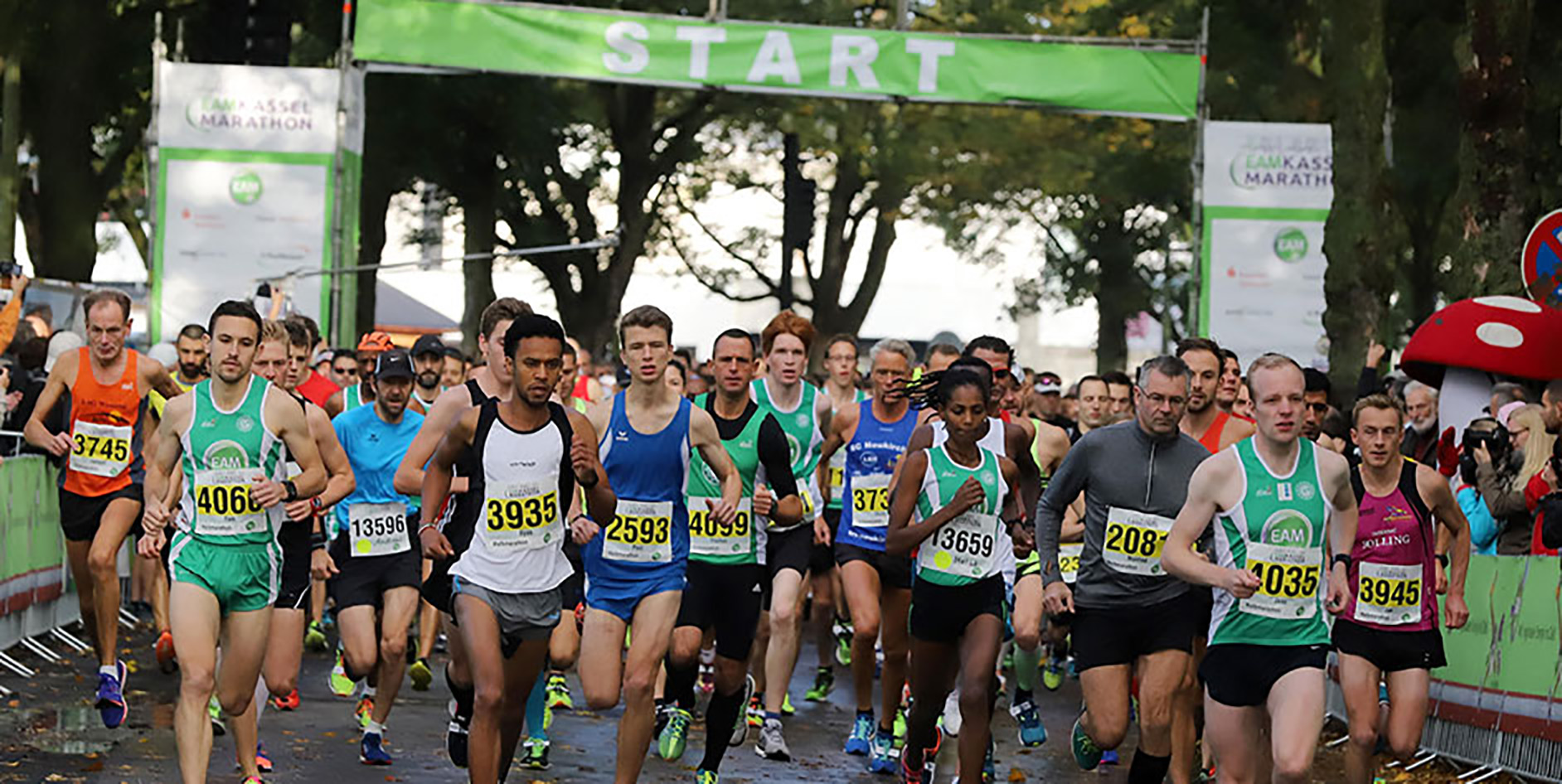 Start des Kasseler Marathons mit laufenden Teilnehmern in Sportbekleidung und Zuschauern im Hintergrund.