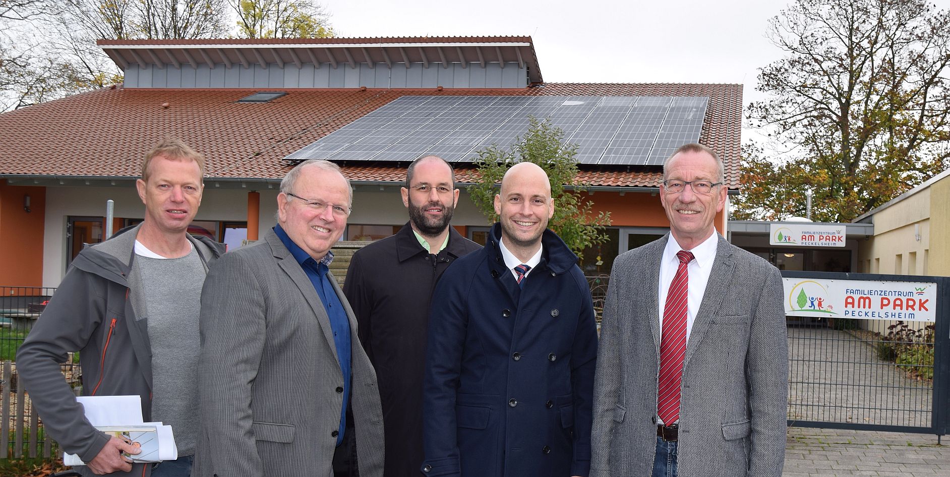 Fünf Personen stehen vor dem Familienstützpunkt am Park in Peckelsheim, mit Solarpanelen auf dem Dach.