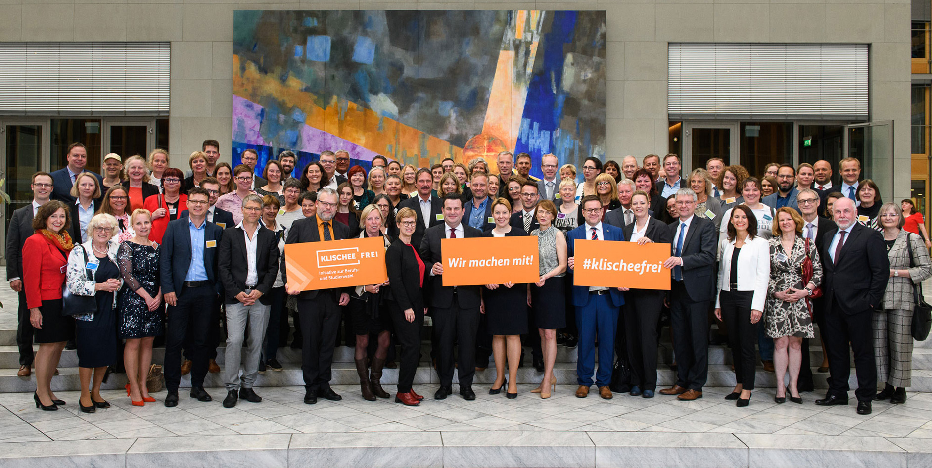 Gruppenbild von Teilnehmern einer Initiative zur Berufs- und Studienwahl, mit bunten Plakaten im Vordergrund.