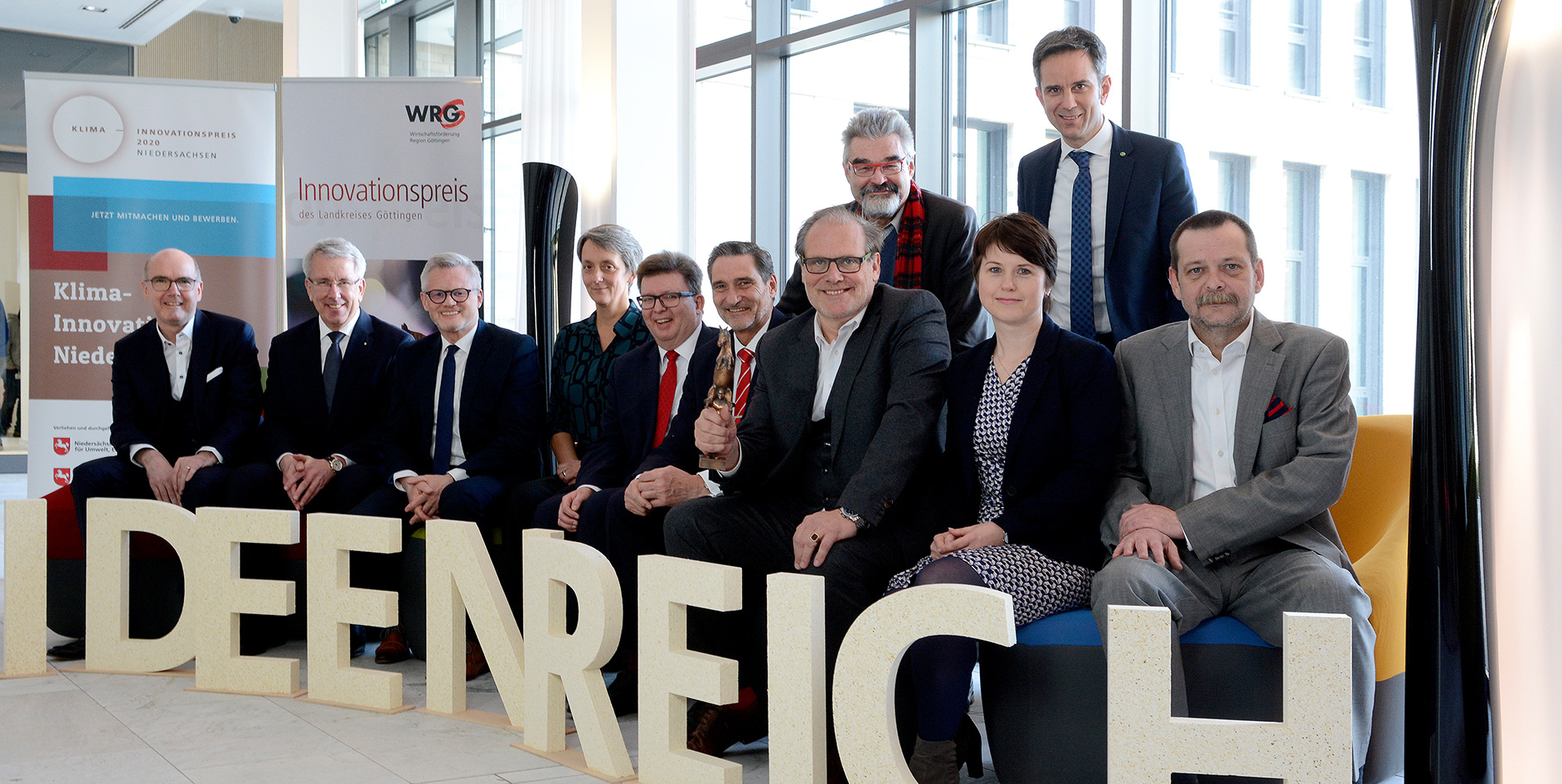 Gruppenteffen von Personen vor großen Buchstaben, die IDEENREICH bilden
