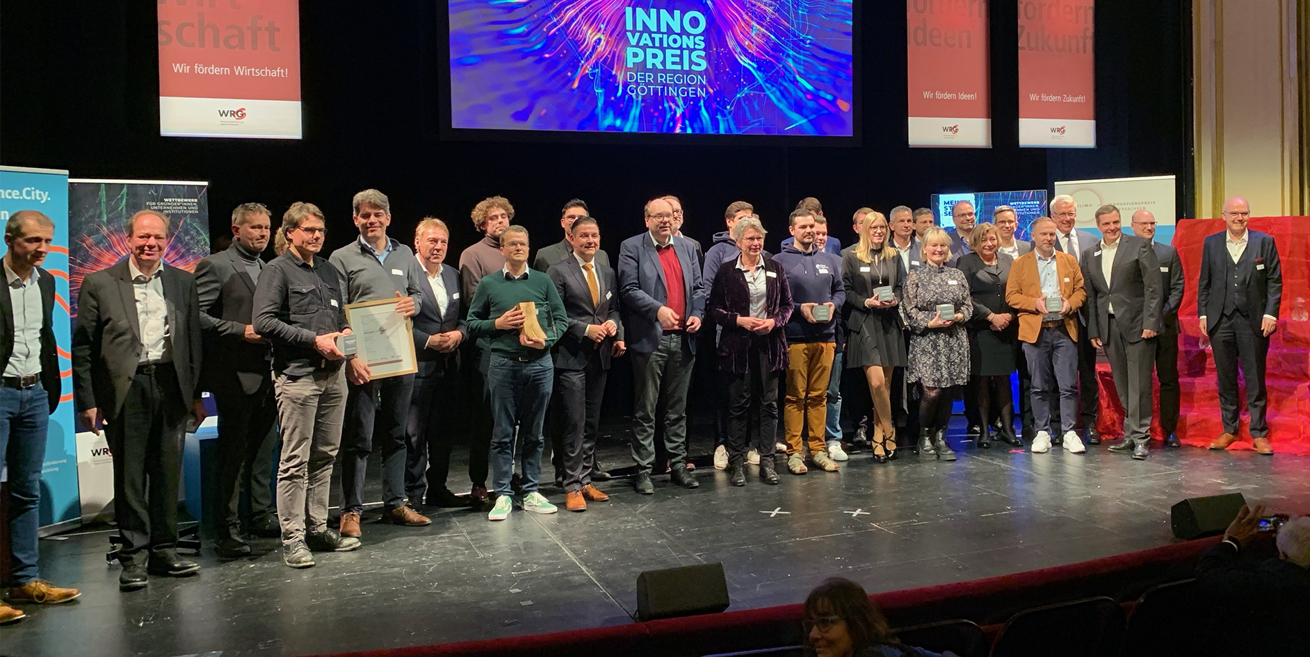 Gruppe von Menschen auf einer Bühne bei der Verleihung des Innovationspreises der Region Göttingen, mit Trophäen in der Hand.