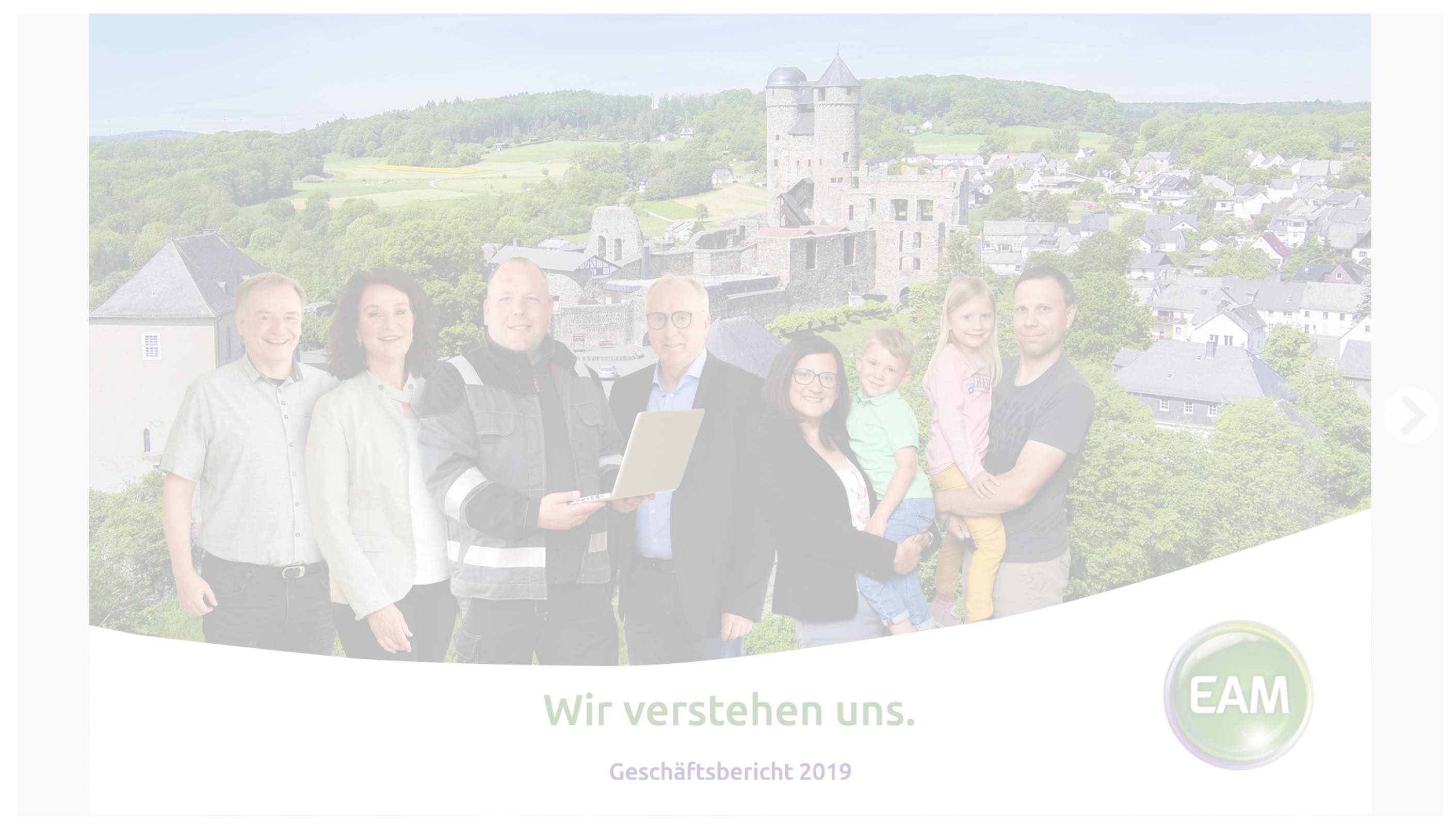 Eine Gruppe von Leuten steht vor einer malerischen Landschaft mit Wald und einer Burg, Titel: "Wir verstehen uns."""
