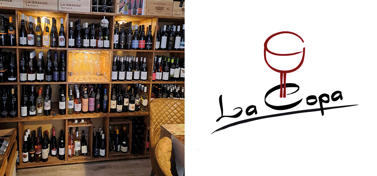 Regal mit Weinflaschen, gefüllt mit verschiedenen Weinsorten; daneben das Logo "La Copa"" mit Weinglas."
