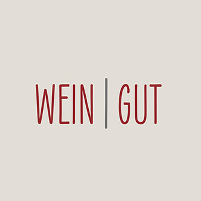 Alt-Tag: Grafik mit den Worten „WEIN | GUT“ in roter Schrift auf hellem Hintergrund.