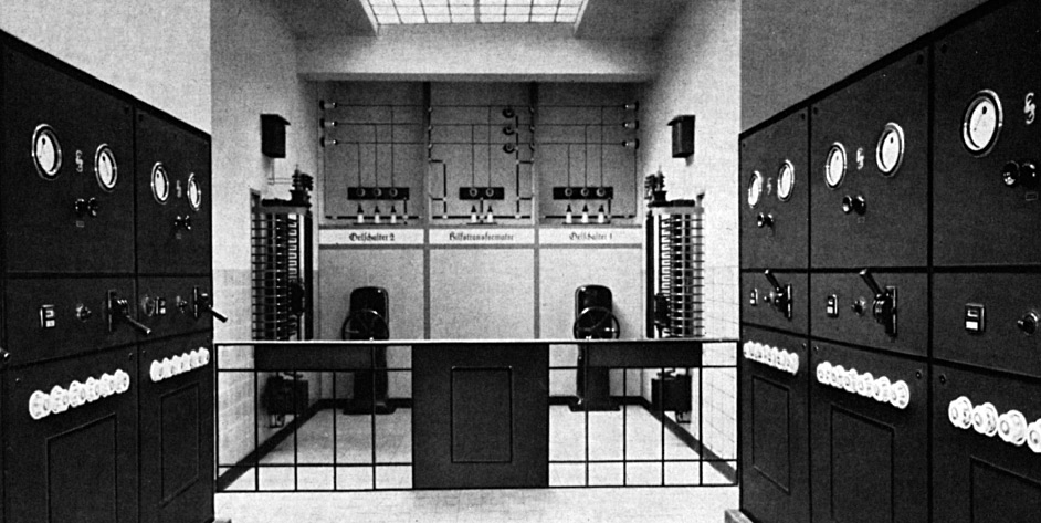 Historischer Kontrollraum mit Schaltschränken und Messgeräten, monochrome Darstellung.
