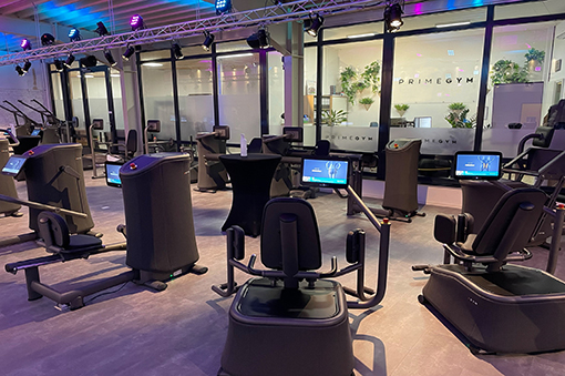 Modernes Fitnessstudio mit verschiedenen Trainingsgeräten und beleuchteter Atmosphäre.