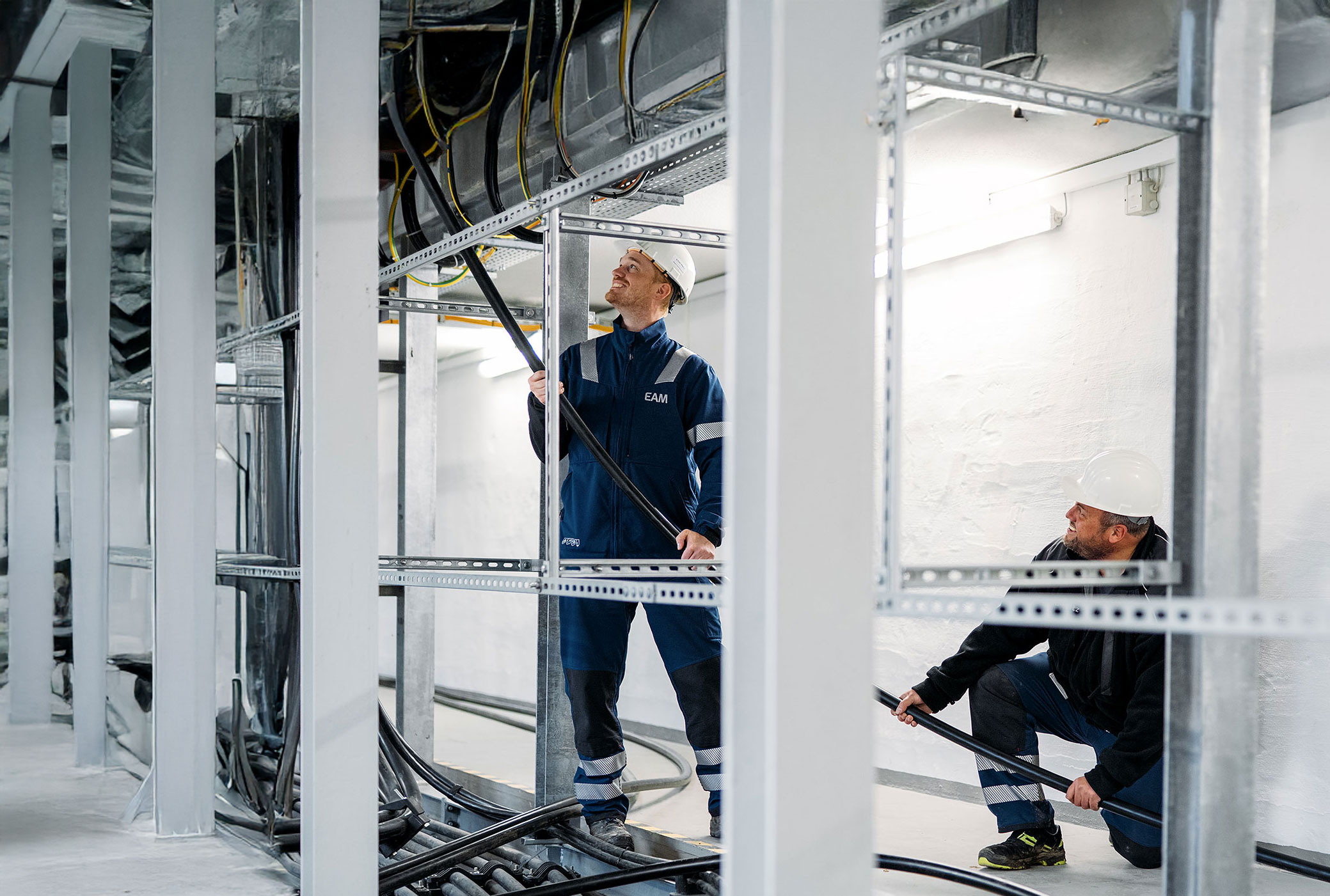 Sechs Personen in Arbeitskleidung und Freizeitkleidung laufen auf einem Kiesweg durch einen bepflanzten Park.
